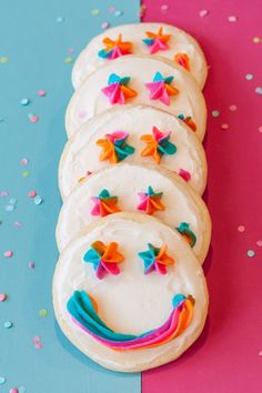 decorated cookies are arranged on a blue and pink surface