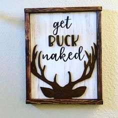 a sign that says get buck naked on the side of a wall with deer antlers