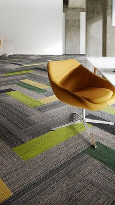 a chair sitting on top of a white table next to a yellow and green chair