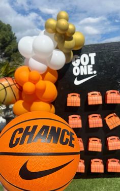 an orange and black basketball next to some balloons