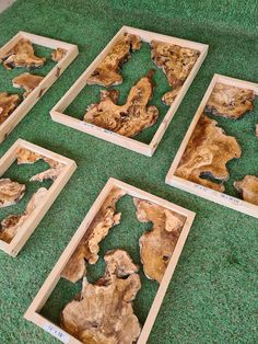 several pieces of wood sitting on top of a green floor next to each other in wooden frames