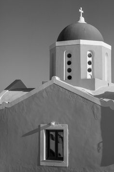 a black and white photo of a building with a cross on top