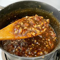 a wooden spoon in a pot filled with food