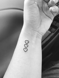 a woman's arm with two hearts on it and the word love written in black ink