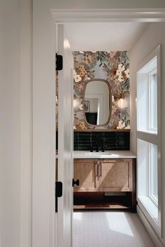 an open door leading to a bathroom with floral wallpaper