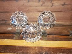 three glass dishes sitting on top of a wooden table