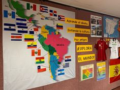 a bulletin board with flags and t - shirts hanging on it's side wall