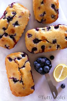 blueberry muffins with lemon slices and fresh blueberries on the side, ready to be eaten