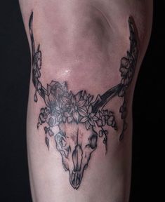 a black and white photo of a cow skull with flowers on it's side