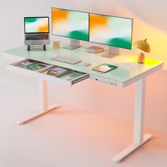 two computer screens sitting on top of a white desk