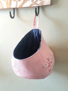 a pink purse hanging from a hook on a wall