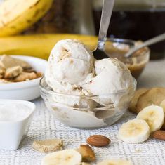 a bowl filled with ice cream next to bananas and nuts