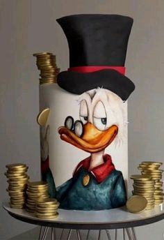 a cake decorated with a duck wearing a top hat and holding stacks of gold coins