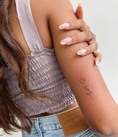 a woman's arm with a rose tattoo on the left side of her arm