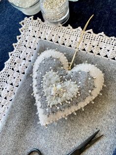 a heart - shaped decoration is sitting on a doily next to scissors