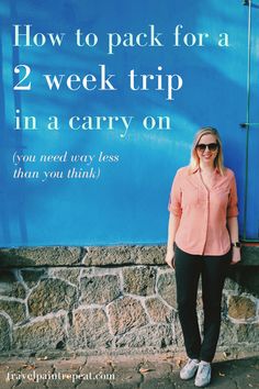 a woman standing in front of a blue sign with the words how to pack for a 2 week trip in a carry on