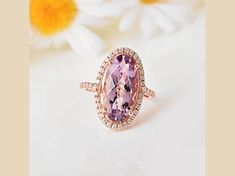 18k rose gold over sterling silver 18x9mm oval amethyst and round moissanite halo design ring. 5.92ctw Oval Amethyst Ring With Halo Setting, Elegant Oval Amethyst Ring In Rose Gold, Elegant Oval Rose Gold Amethyst Ring, Elegant Rose Gold Oval Amethyst Ring, Fine Jewelry Lavender Oval Jewelry, Lavender Oval Fine Jewelry, Rose Gold Amethyst Ring With Halo Setting, Rose Gold Oval Amethyst Ring With Center Stone, Rose Gold Amethyst Jewelry With Halo Setting