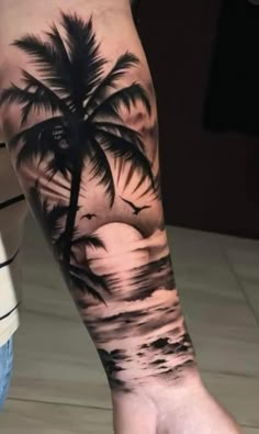 a person with a palm tree tattoo on their arm and foot, while the sun is setting