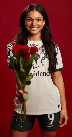 a woman holding a bouquet of roses in her hands