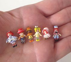 small toy figurines sitting in the palm of someone's hand