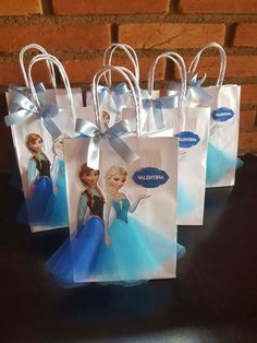 small frozen princess bags with blue bows on the handles are sitting on a black table