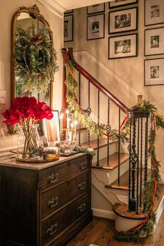 a christmas scene with candles and wreaths on the bannister next to stairs