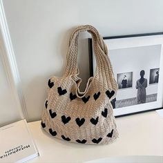 a knitted bag sitting on top of a table next to a framed photo and a book