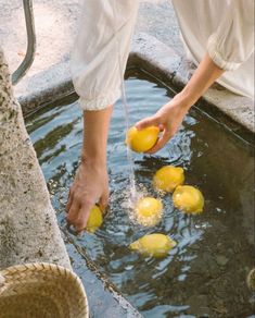 a person is pouring lemons into the water