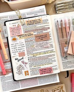 an open bible with markers and pens on it