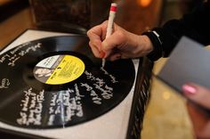 a person writing on a record with a pencil