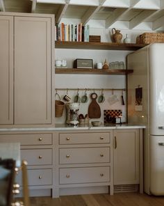 a white refrigerator freezer sitting inside of a kitchen next to a wooden counter top