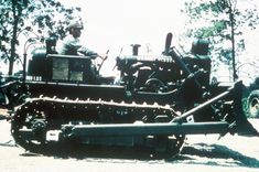 an old photo of a man sitting on top of a tractor