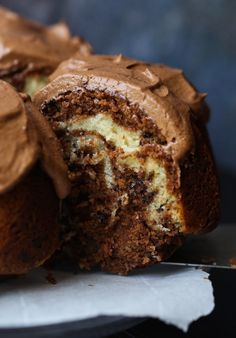 a close up of a cake with chocolate frosting on the top and one half eaten