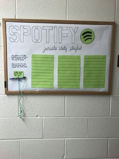 a bulletin board on the wall displaying spotify's music playlist for students