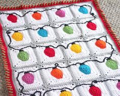 a crocheted blanket with multicolored balls on it