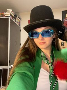 a woman wearing sunglasses and a hat with a pom - pom around her neck