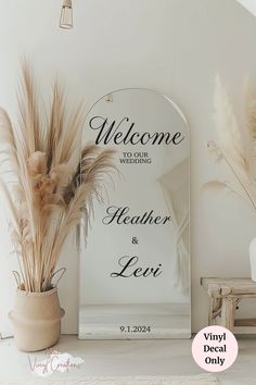 the welcome sign is next to a vase with pamodia and pamodia in it