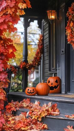 two pumpkins sitting on the steps in front of a house with fall leaves around them