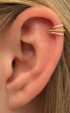 a close up of a person's ear with a gold ring on top of it