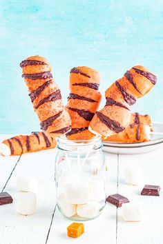 marshmallows and chocolate dipped pretzels in a jar on a table