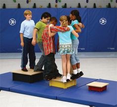 four children standing on a podium with their arms around each other and one boy in the middle