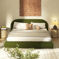 a bedroom with a green headboard and white bedding, two lamps on either side of the bed