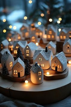 many small houses are lit up on a wooden tray with candles in the shape of houses