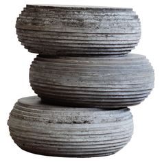 three cement pots stacked on top of each other in front of a white background,