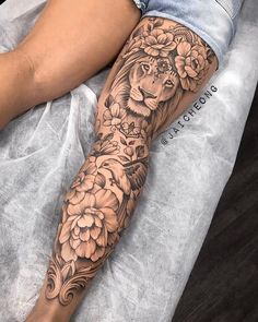 a woman's leg with a lion and flowers tattoo on her left calf sleeve