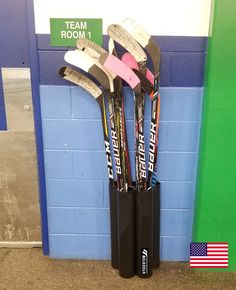 a group of hockey sticks sitting in the corner of a room