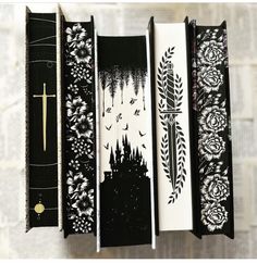 four black and white bookmarks hanging from a line with designs on them, each containing a cross