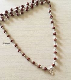 "Sterling Silver Rudraksha Necklace. This beaded necklace can be worn by men as well as women. This Mala can be worn in multiple ways, it can be worn as it is, or you can attach a pendant/tassel in the lock of this Mala to wear it as a pendant necklace. About Rudraksha:-- Rudraksha have been traditionally used as prayer beads. They are associated with Lord Shiva and the name Rudraksha translates to the Shiva's tears. They commonly worn by his devotees. They are worn as a form of protection as th Silver Rudraksha Mala, Spiritual Silver Beaded Necklaces For Puja, Spiritual Necklaces With Silver Beads For Puja, Spiritual Silver Beads Mala Gift, Spiritual Beaded Chain Jewelry For Festivals, Spiritual Jewelry With Beaded Chain For Festivals, Brown Necklaces For Puja And Festivals, Festival Brown Necklace For Puja, Spiritual Silver Beads Necklaces For Festivals