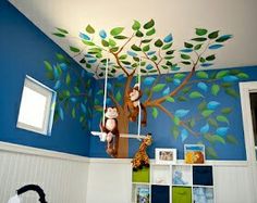 a child's bedroom decorated in blue and green with monkeys hanging from the tree