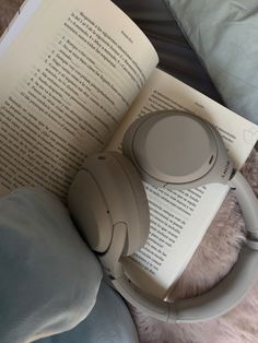 an open book with headphones on top of it